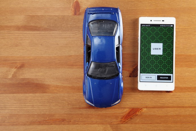 Uber app next to toy car.